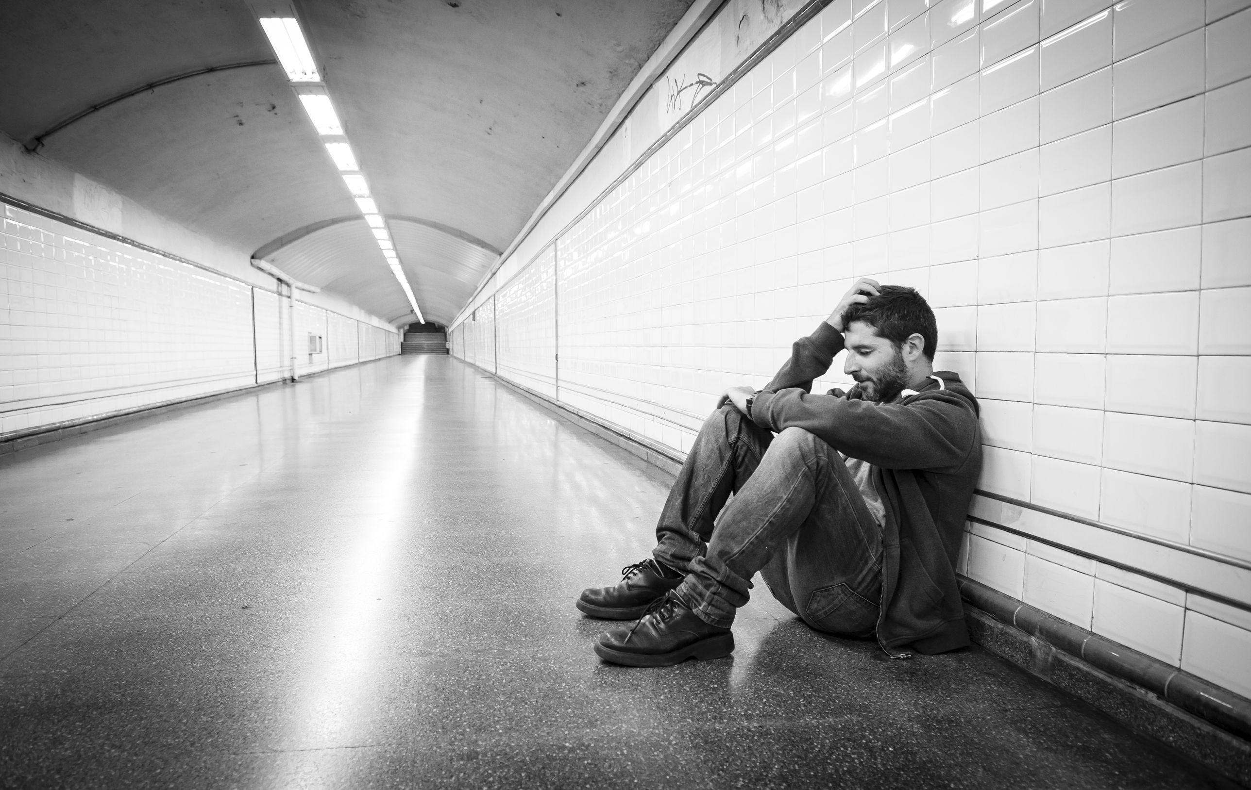 Будь проще психология. Парень сидит у стены. Мужчина сидит у стены. Человек у стены. Одинокий человек в метро.